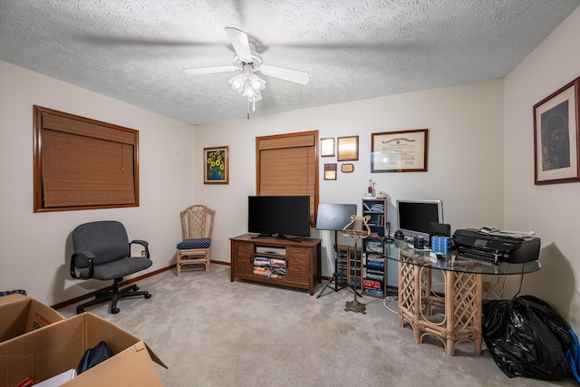 carpeted home office featuring a textured ceiling and ceiling fan