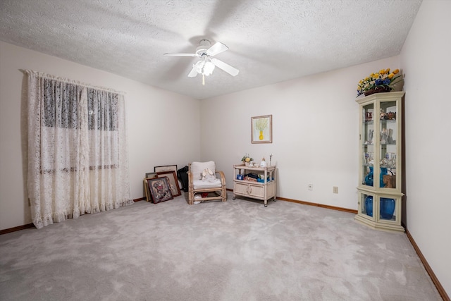 unfurnished room with a textured ceiling, carpet floors, and ceiling fan