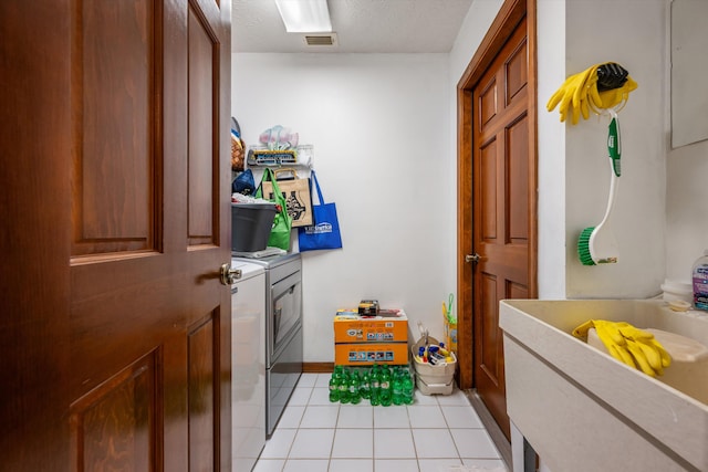 washroom with light tile patterned floors and washer and clothes dryer