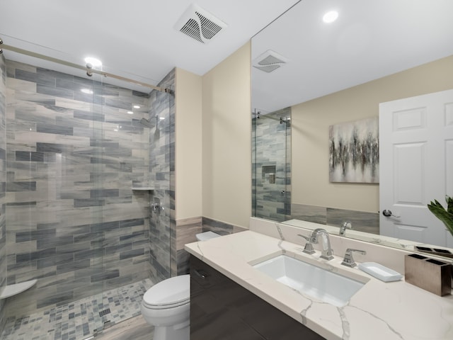 bathroom with walk in shower, vanity, toilet, and tile walls