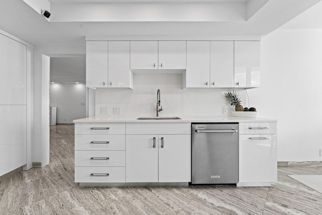 kitchen with light hardwood / wood-style floors, white cabinetry, stainless steel dishwasher, and sink