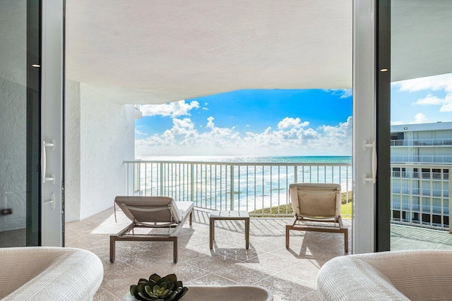 balcony with a water view and a beach view