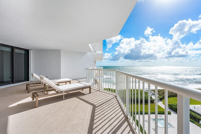 balcony with a water view and a beach view