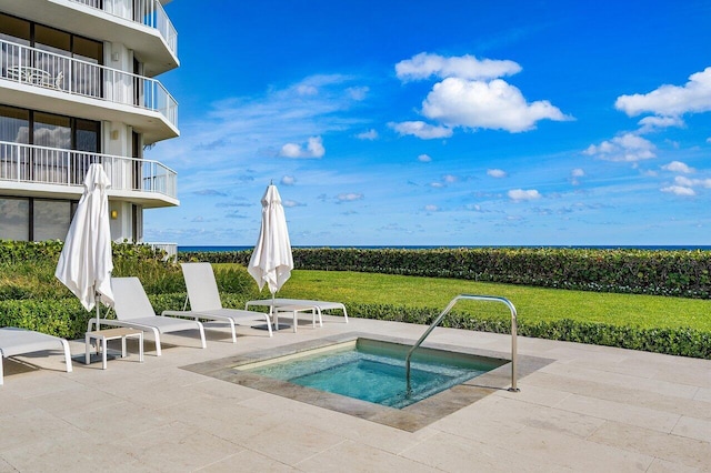 view of pool featuring an in ground hot tub, a yard, and a patio