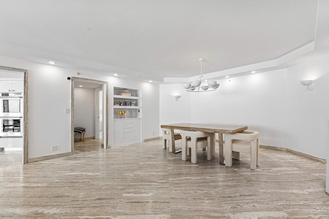 dining area featuring a chandelier and built in shelves