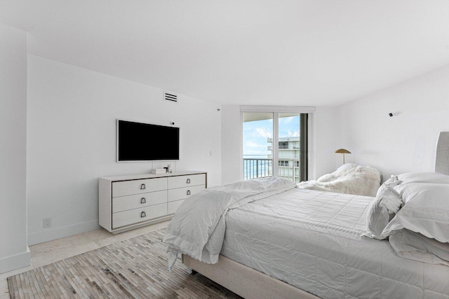 bedroom with access to exterior and light hardwood / wood-style floors