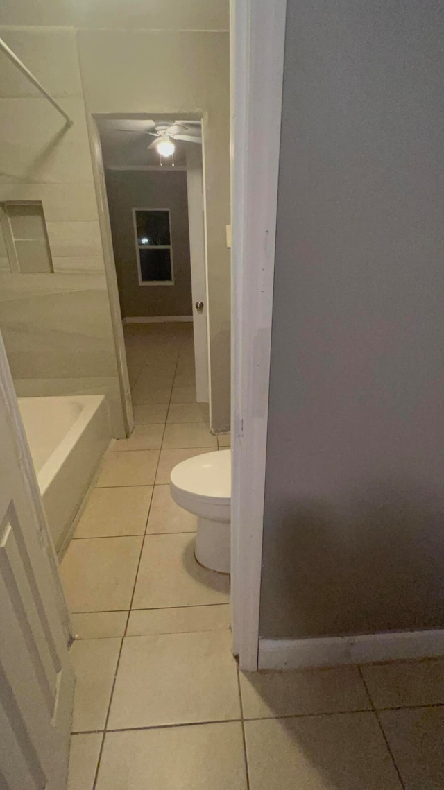 bathroom with tile patterned flooring, shower / tub combination, and toilet