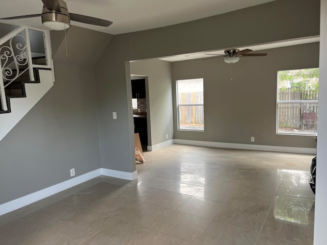 unfurnished living room featuring ceiling fan and a wealth of natural light