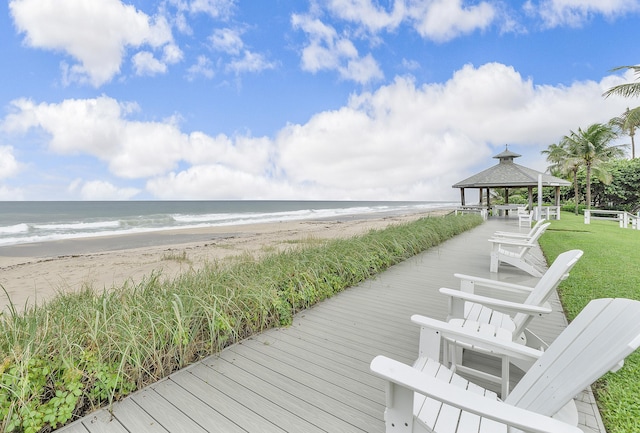 surrounding community featuring a gazebo, a water view, and a beach view