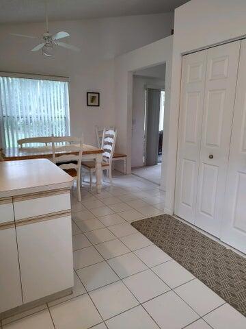 unfurnished dining area featuring vaulted ceiling, ceiling fan, and light tile patterned floors