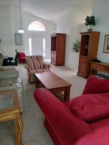 carpeted living room featuring high vaulted ceiling