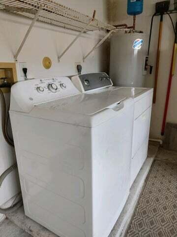 laundry room featuring water heater and separate washer and dryer