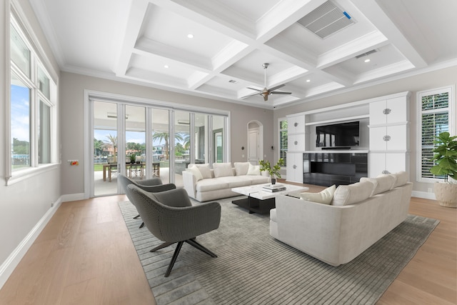 living room with light wood-type flooring, ceiling fan, ornamental molding, and beam ceiling