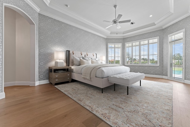 bedroom featuring ceiling fan, crown molding, a tray ceiling, and access to outside