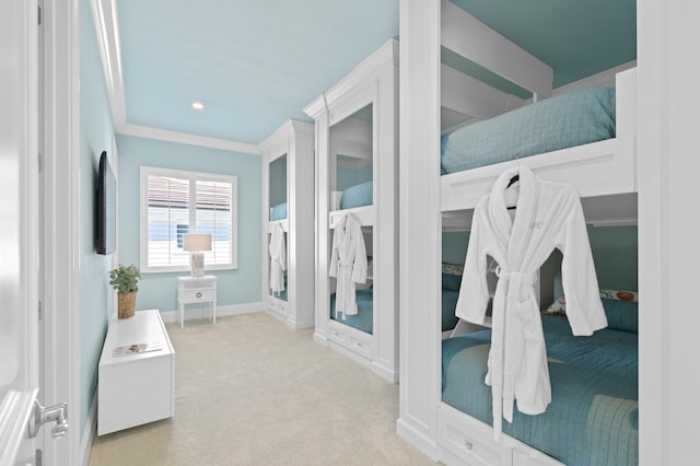 bedroom with ornamental molding and light colored carpet