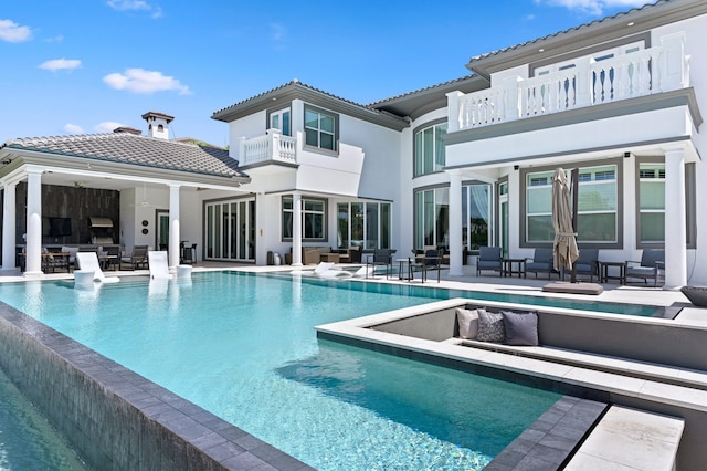 rear view of property with an outdoor hangout area, a balcony, and a patio