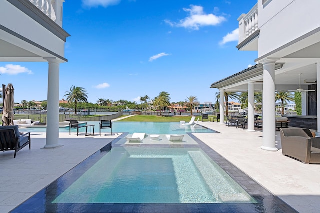 view of pool with a water view, an in ground hot tub, and a patio