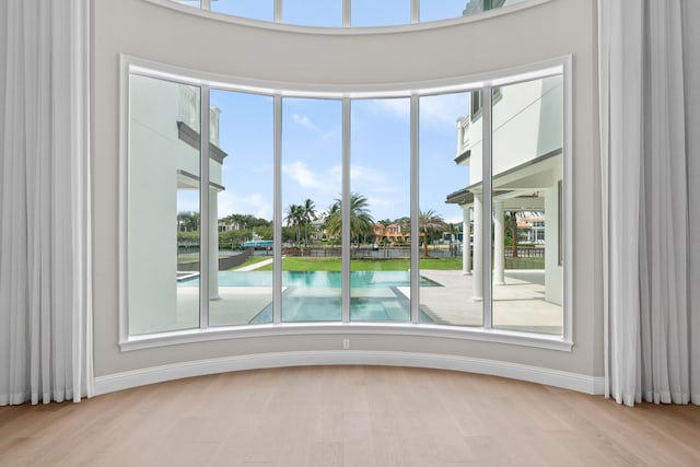 unfurnished room with light wood-type flooring and a water view