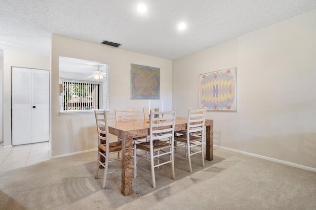 carpeted dining area featuring ceiling fan and a textured ceiling