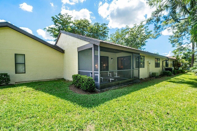 rear view of property featuring a lawn and a sunroom