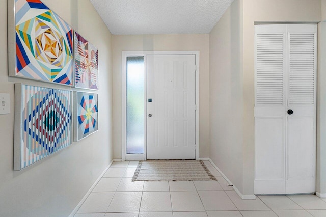 foyer with a textured ceiling and light tile patterned floors