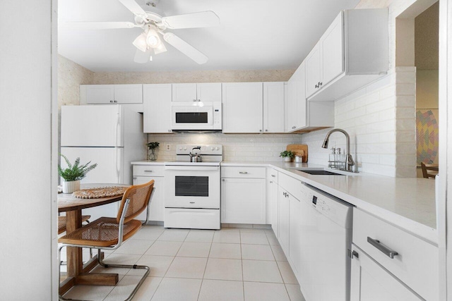 kitchen featuring white appliances, white cabinets, tasteful backsplash, sink, and light tile patterned floors