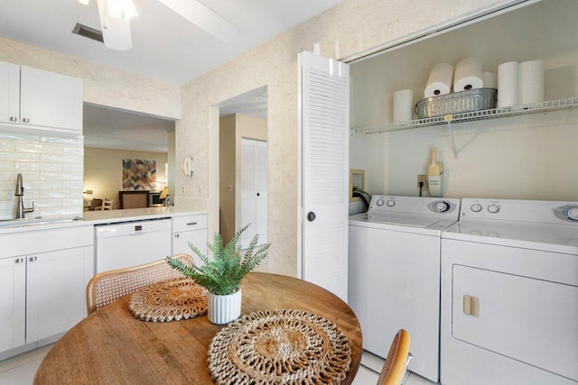 washroom with sink, ceiling fan, light tile patterned floors, and washer and dryer