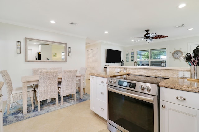 kitchen with light stone counters, ceiling fan, white cabinetry, and stainless steel appliances