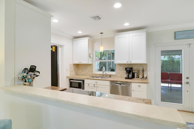 kitchen featuring decorative light fixtures, sink, stainless steel appliances, ornamental molding, and white cabinets