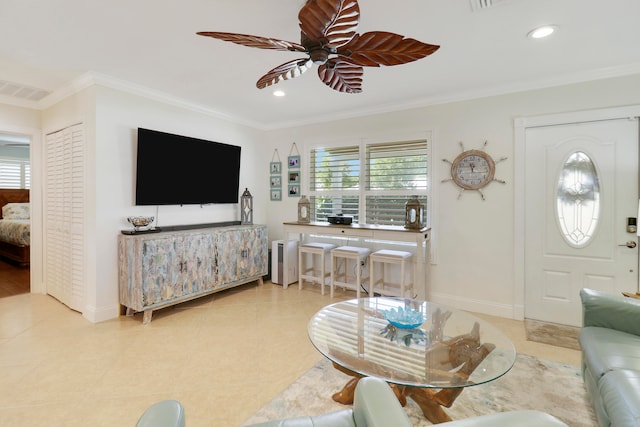 tiled living room with ceiling fan and crown molding