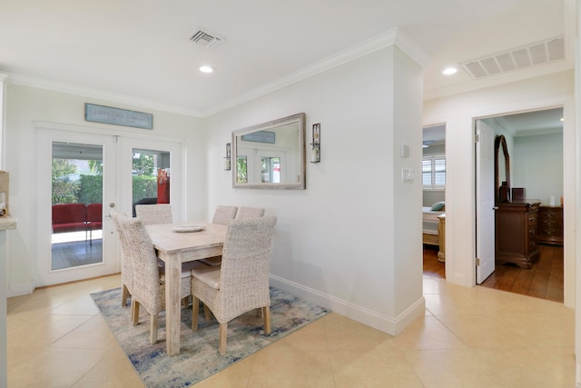 tiled dining area featuring crown molding and french doors