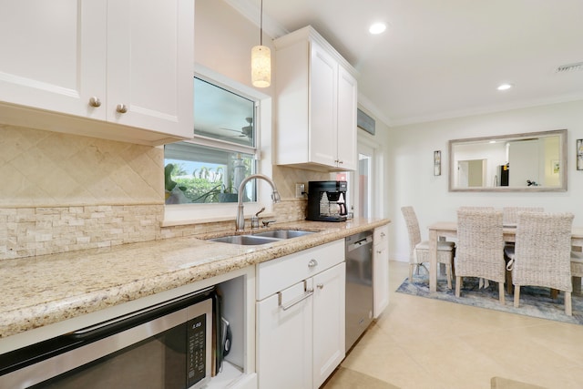 kitchen featuring pendant lighting, sink, backsplash, appliances with stainless steel finishes, and white cabinetry