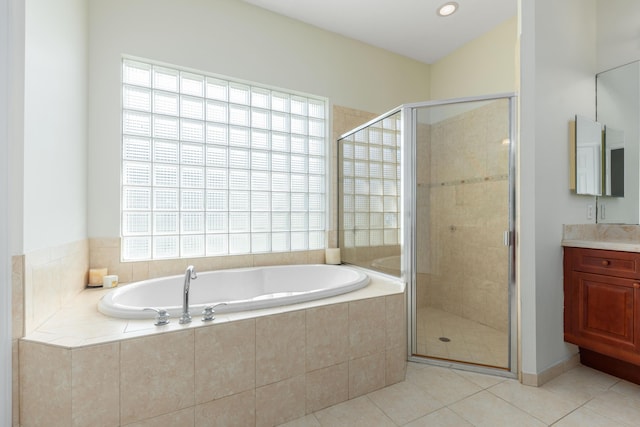bathroom with a stall shower, tile patterned floors, a garden tub, and vanity