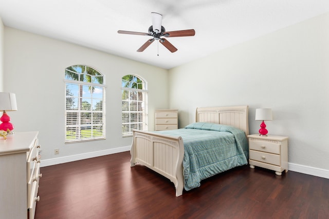 bedroom featuring baseboards, a ceiling fan, and dark wood finished floors
