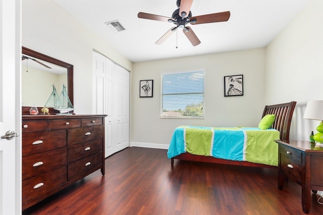 bedroom featuring ceiling fan, baseboards, wood finished floors, visible vents, and a closet