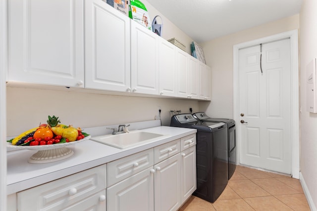 laundry room with washing machine and dryer, light tile patterned flooring, baseboards, a sink, and cabinet space