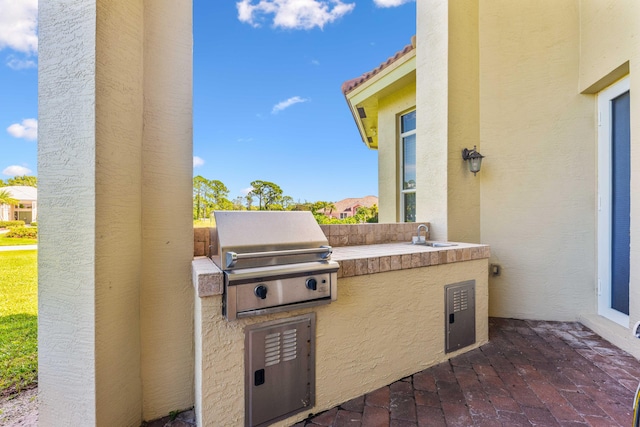 view of patio featuring an outdoor kitchen, a sink, and area for grilling