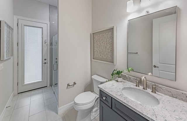 bathroom featuring vanity, tile patterned flooring, a shower with door, and toilet