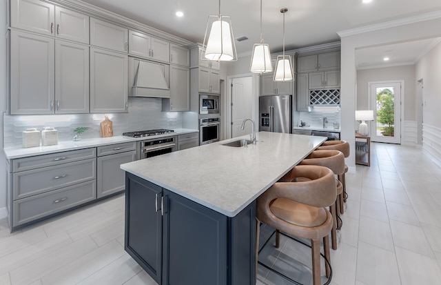 kitchen with sink, a breakfast bar area, stainless steel appliances, an island with sink, and custom exhaust hood