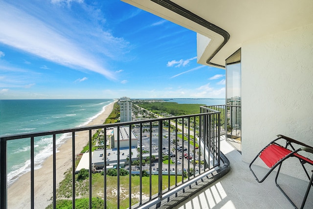 balcony with a water view and a view of the beach