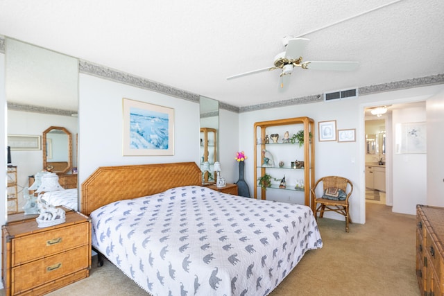 carpeted bedroom featuring ensuite bath, ceiling fan, and a textured ceiling