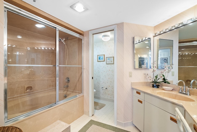 full bathroom featuring vanity, tile patterned flooring, combined bath / shower with glass door, and toilet