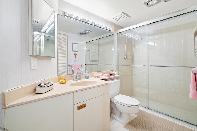 bathroom featuring vanity, tile patterned flooring, toilet, and an enclosed shower