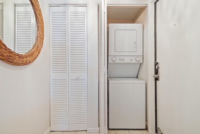 washroom featuring stacked washer and clothes dryer and light tile patterned floors