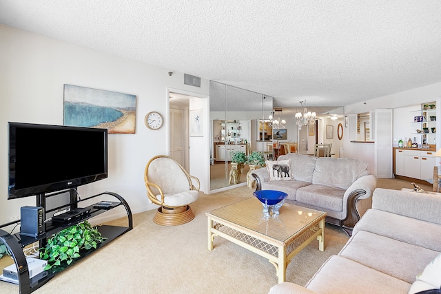 carpeted living room with a notable chandelier and a textured ceiling