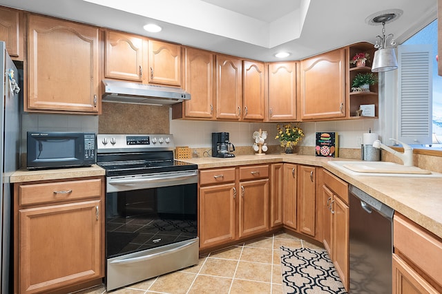 kitchen with pendant lighting, tasteful backsplash, sink, black appliances, and light tile patterned floors