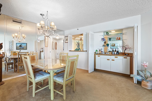 carpeted dining room with a notable chandelier, sink, and a textured ceiling