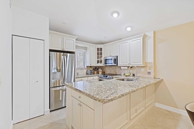 kitchen featuring light stone countertops, sink, white cabinets, and appliances with stainless steel finishes