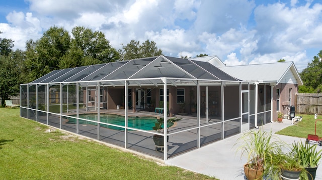 back of house with a yard, a fenced in pool, glass enclosure, and a patio area