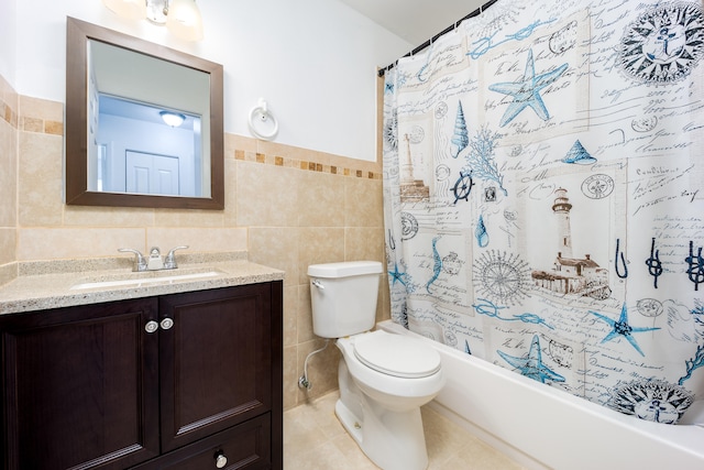 full bathroom featuring toilet, shower / bathtub combination with curtain, vanity, and tile walls